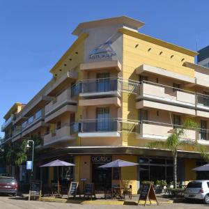 un edificio amarillo con sombrillas delante en Hotel Plaza en Colón