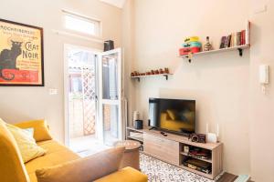 a living room with a couch and a television at Ca' Balenga - Cozy Stay in the Old Town with Free Private Parking in Asti