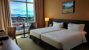 una camera d'albergo con due letti e una finestra di Pan Borneo Hotel Kota Kinabalu a Kota Kinabalu