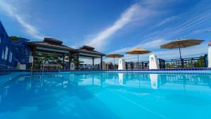 a large swimming pool with umbrellas and a building at Benikea Swiss Rosen Hotel in Gyeongju