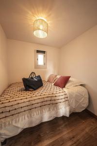 Un dormitorio con una cama con una bolsa. en Carcassonne mon amour, en Carcassonne