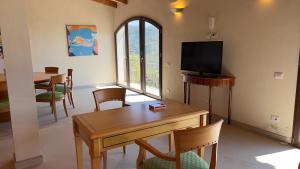 - un salon avec une table et une télévision dans l'établissement Torre delle Stelle Residence, à Torre delle Stelle