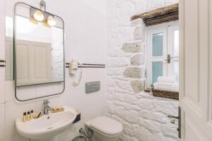 a white bathroom with a sink and a mirror at Panjur Alaçatı in Alacati