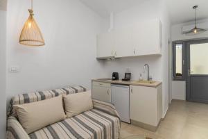 a living room with a couch and a kitchen at Agathi's House in Triovasálos +8 photos