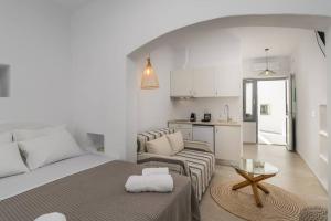 a white living room with a bed and a couch at Agathi's House in Triovasálos