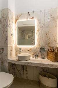 een badkamer met een wastafel, een spiegel en een toilet bij Agathi's House in Triovasálos