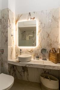 a bathroom with a sink and a mirror and a toilet at Agathi's House in Triovasálos