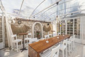 a greenhouse with a wooden table and white chairs at Panjur Alaçatı in Alaçatı