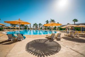 einen Pool mit Stühlen und Sonnenschirmen in der Unterkunft Labranda Royal Makadi in Hurghada