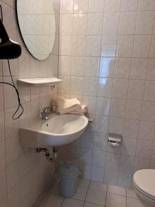 uma casa de banho com um lavatório, um espelho e um WC. em Haus am Mühlenpark Whg. 4 em Cuxhaven