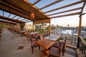 a patio with tables and chairs and a view of the water at JAZ Palmariva Beach in Hurghada