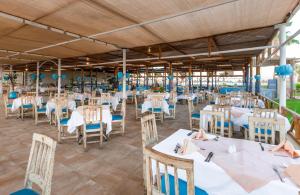 a dining area with white tables and chairs at JAZ Palmariva Beach in Hurghada +28 photos