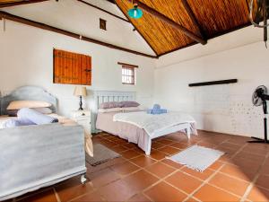 a bedroom with two beds and a couch at Wiggins Self Catering in Jacobs Bay