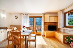 a kitchen and dining room with a table and chairs at Ferienwohnung Sonnegg in Saltusio