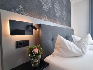 ein Schlafzimmer mit einem Bett und einem Fernseher an der Wand in der Unterkunft CAP1 Boardinghouse in Baesweiler