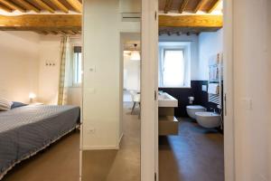 um quarto com uma cama e uma casa de banho com um lavatório em Appartamento il Poggino em Colle Val D'Elsa
