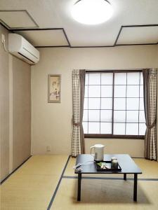una camera con un tavolo di fronte ad una grande finestra di HOTEL HOUSE LEE a Tokyo Altre 2 foto