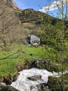 una casa en una colina junto a un río en Gavarent en Gavarnie