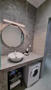 bagno con lavandino, specchio e lavatrice di Midoya Sea View a Skaleta