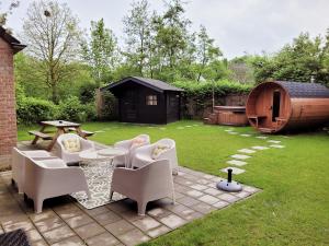 eine Terrasse mit Stühlen und einem Tisch im Hof in der Unterkunft Scandinavian Wellness met hottub & sauna in Ewijk