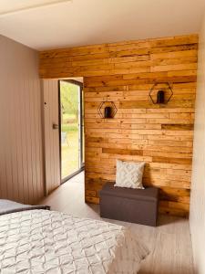 a bedroom with a wooden accent wall with a bed at Casterton stays 