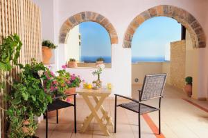 a room with two arched windows and a table and chairs at Stefanos Village Hotel in Plakias