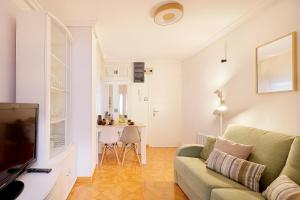 een woonkamer met een bank en een tafel bij 142A Apto 2 habitaciones Playa San Lorenzo in Gijón