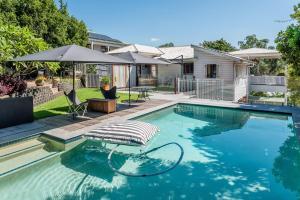 uma piscina com uma cama e um guarda-sol em Homely Hideaway Bardon em Brisbane