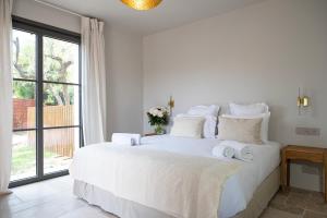 um quarto com uma cama branca e toalhas em Lou Cagnard em Saint-Tropez