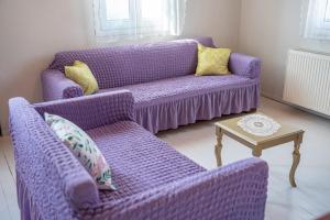 a purple couch and two chairs in a living room at Pitoros Summer Cottage Kefalonia in Mesovoúnia