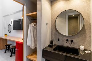 a bathroom with a sink and a mirror at Hippocampus Hotel in Kamari