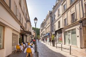 une rue vide avec des tables, des chaises et des bâtiments dans l'établissement La vie en bleu - Studio proche de Paris, à Charenton-le-Pont