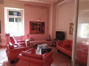 a living room with red furniture and a tv at Ostello delle cartiere in Toscolano Maderno