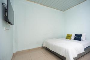 Tempat tidur dalam kamar di Urbanview Hotel My Home Ciracas