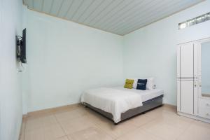 Tempat tidur dalam kamar di Urbanview Hotel My Home Ciracas