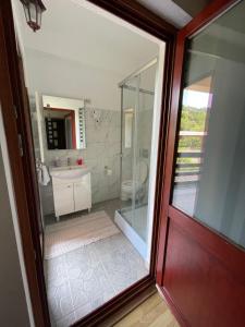 La salle de bains est pourvue d'un lavabo et d'une porte en verre. dans l'établissement GAMA Restaurant Cazare, à Vişeu de Sus