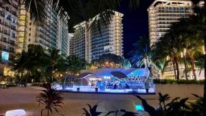 a night view of a building with people in it at Manila Urban Resort at Azure in Manila