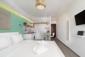 a bedroom with a white bed and a desk at Seaside Secret by BluPine in Athens