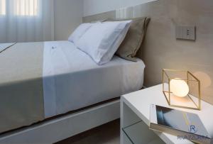 a bedroom with a bed and a table with a lamp at Rivazzurra Beach Rooms in San Vito lo Capo