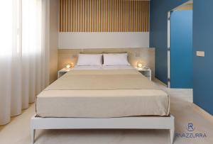 a bedroom with a large bed with two lamps on it at Rivazzurra Beach Rooms in San Vito lo Capo