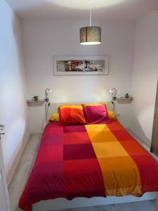 Una cama en una habitación con una manta colorida. en Appartement vue mer imprenable., en Sisco