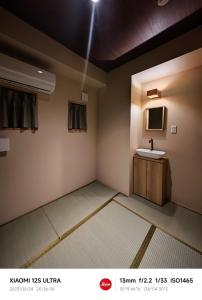 a bathroom with a sink and a mirror at 2023年6月開業 サカエ ゲストハウス in Nagoya