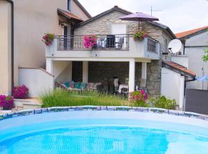 a house with a swimming pool in front of a house at Guesthouse Pupa Opatija Istra in Jurdani
