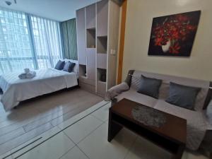 ein Wohnzimmer mit einem Bett und einem Sofa in der Unterkunft Sunshine Properties at One Uptown BGC in Manila