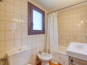 uma casa de banho com um WC, um lavatório e uma janela em apartament amb piscina comunitària al Golfet em Calella de Palafrugell