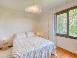 um quarto branco com uma cama e uma janela em apartament amb piscina comunitària al Golfet em Calella de Palafrugell