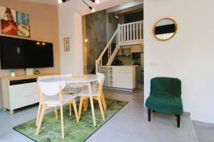 a living room with a table and chairs and a television at GASSPON - Golfe de St-Tropez - Mazet dans domaine privé avec piscine et tennis in Cogolin