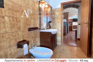 a bathroom with a sink and a toilet and a mirror at Il Borgo dall'alto in Lavagna