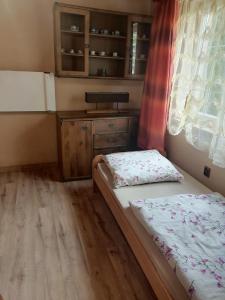 a small bedroom with a bed and a window at Całoroczny Domek Dwukondygnacyjny in Baligród