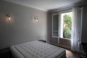 um quarto com uma cama e uma janela em Montmartre sacré cœur em Paris